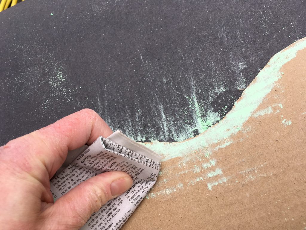 Brushing the chalk to create aurora patterns