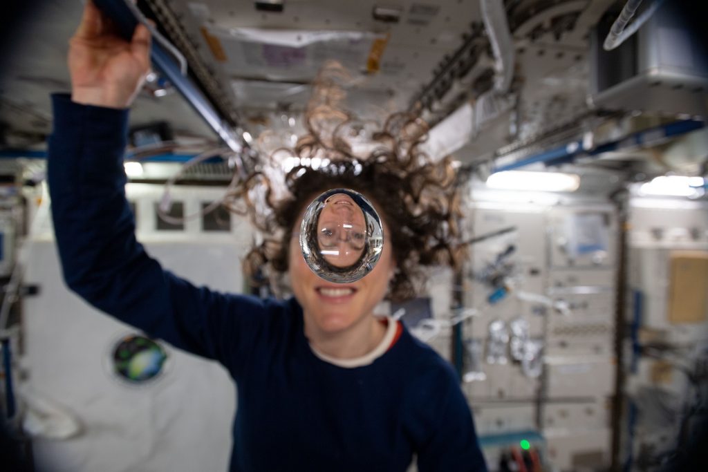 Expedition 60 Flight Engineer Christina Koch of NASA playfully demonstrates how fluids behave in the weightless environment of microgravity aboard the International Space Station.