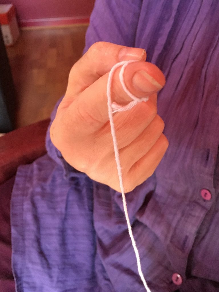 Tie the end of the string around your finger to stop it falling out of the straw